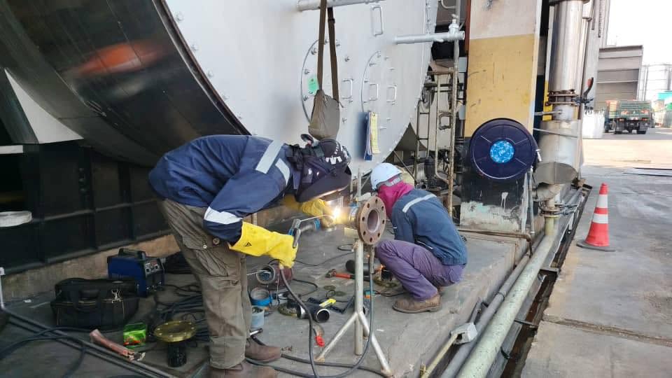 PK Comrades engineers welding pipework during boiler safety valve conversion at an oil refinery in Malaysia