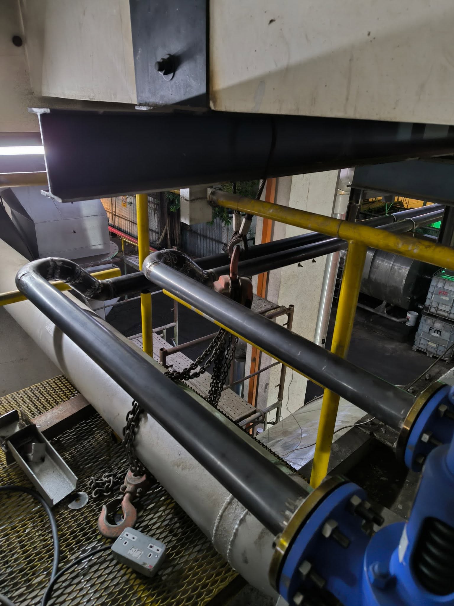 Chain hoist rigging and pipework during boiler safety valve conversion at oil refinery in Malaysia