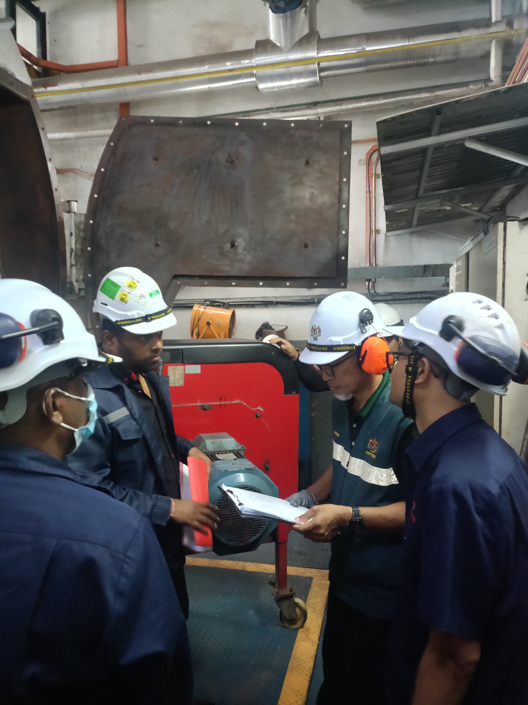 JKKP officer reviewing boiler compliance documents with PK Comrades technicians during a plant inspection in Malaysia